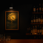 バーカウンターの壁に飾られた写意画と照明、周囲にはボトル棚が並ぶ様子
